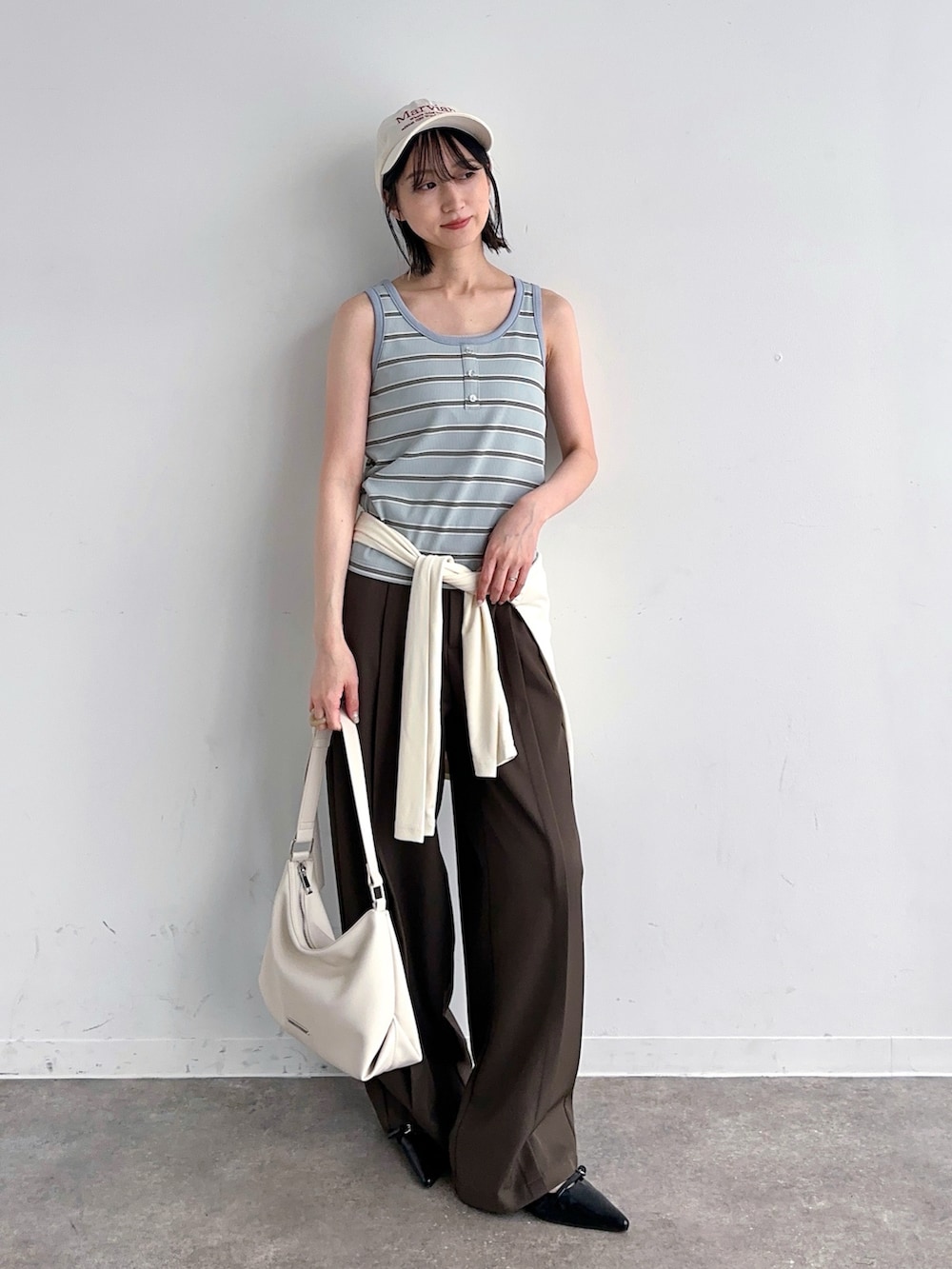 ホワイト系のTシャツ/カットソー、ブルー系のタンクトップ、ブラウン系のスラックスを着用したレディースの夏コーディネートの2枚目の写真