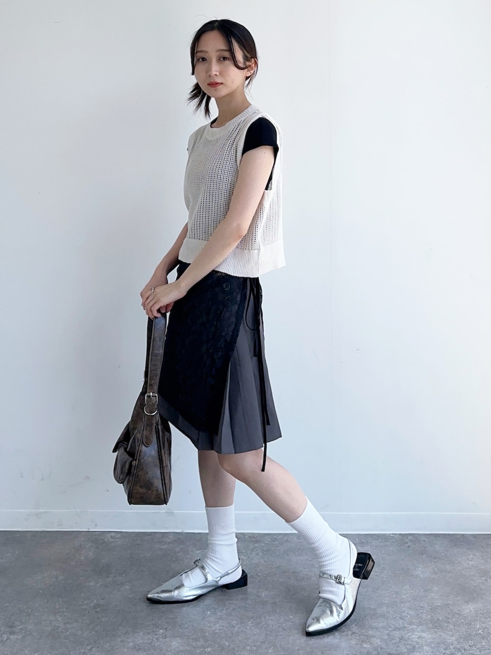 グレー系のスカート、ブラック系のTシャツ/カットソー、ブラック系のスカートを着用したレディースの秋コーディネートの2枚目の写真