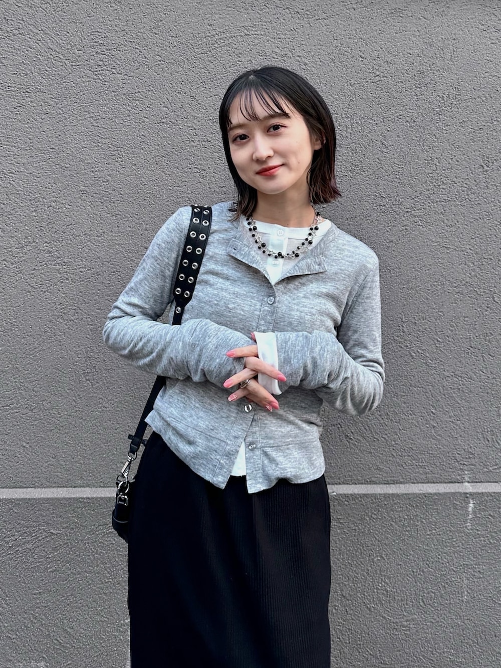 グレー系のカーディガン/ボレロ、ホワイト系のカーディガン/ボレロ、ブラック系のスカートを着用したレディースの春コーディネートの5枚目の写真