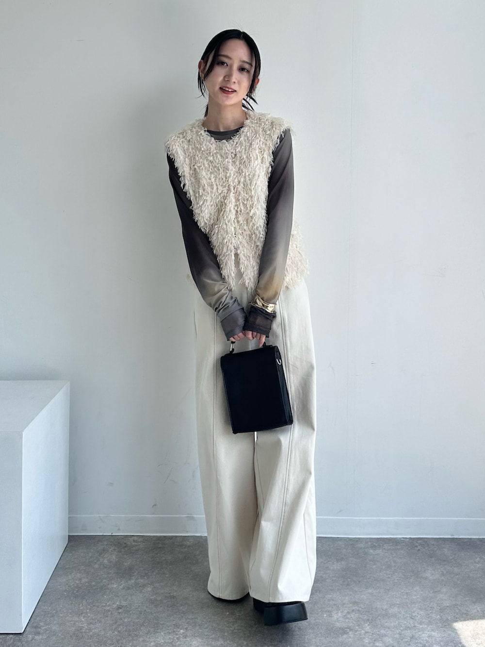 ホワイト系のベスト、ホワイト系のその他パンツ、ブラック系のTシャツ/カットソーを着用したレディースの春コーディネートの3枚目の写真