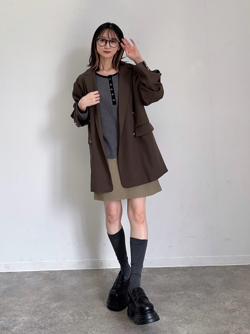 ブラウン系のテーラードジャケット、ベージュ系のスカート、ブラック系のローファーを着用したレディースの秋コーディネートの2枚目の写真