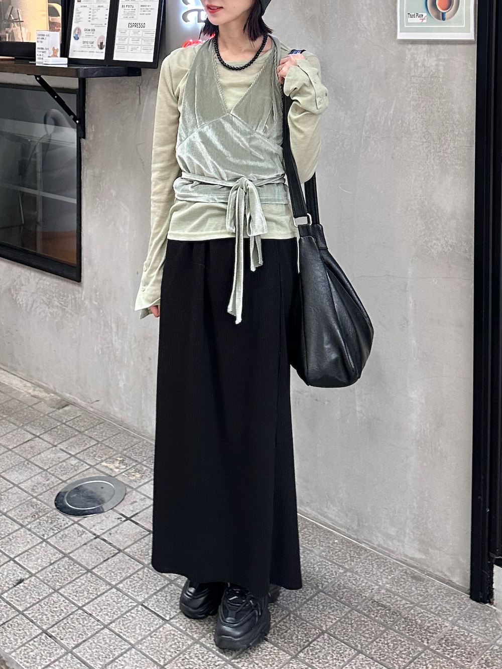 ブラック系のスカート、グリーン系のTシャツ/カットソー、ブラック系のショルダーバッグを着用したレディースの秋コーディネートの2枚目の写真
