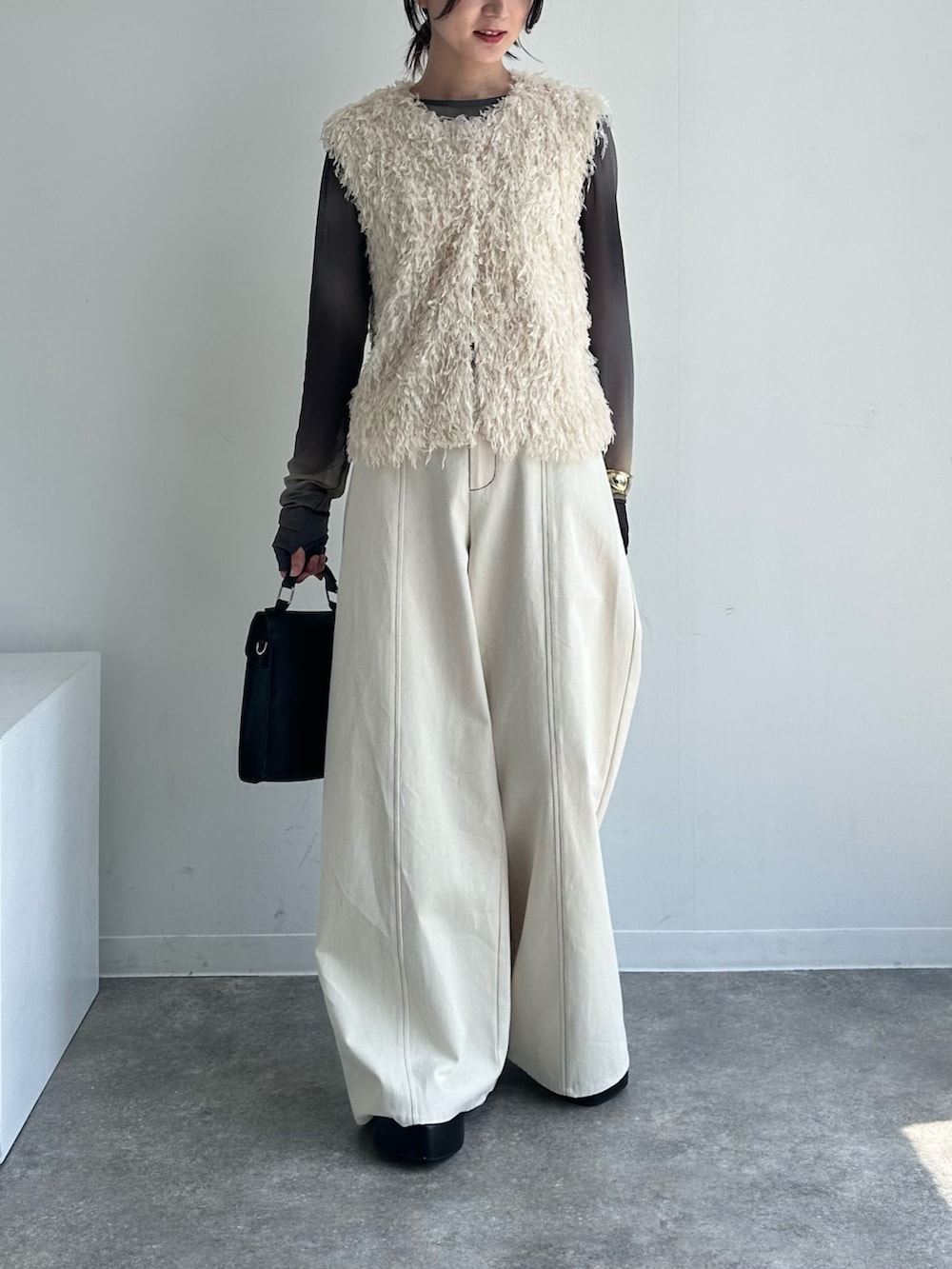 ホワイト系のベスト、ホワイト系のその他パンツ、ブラック系のTシャツ/カットソーを着用したレディースの春コーディネートの2枚目の写真