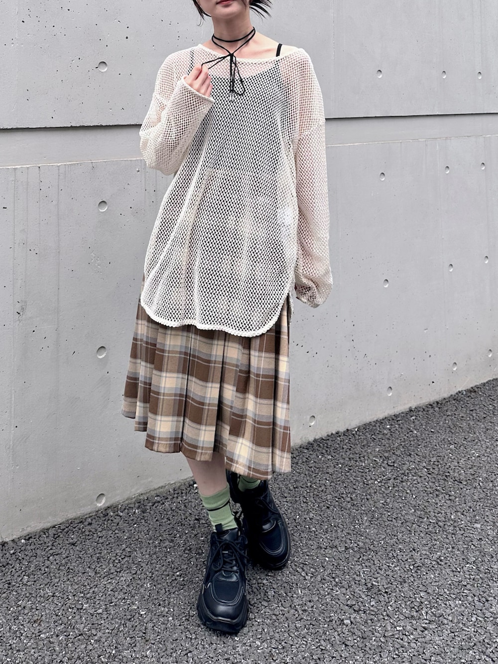 ベージュ系のスカート、ホワイト系のTシャツ/カットソー、ブラック系のスニーカーを着用したレディースの春コーディネートの2枚目の写真