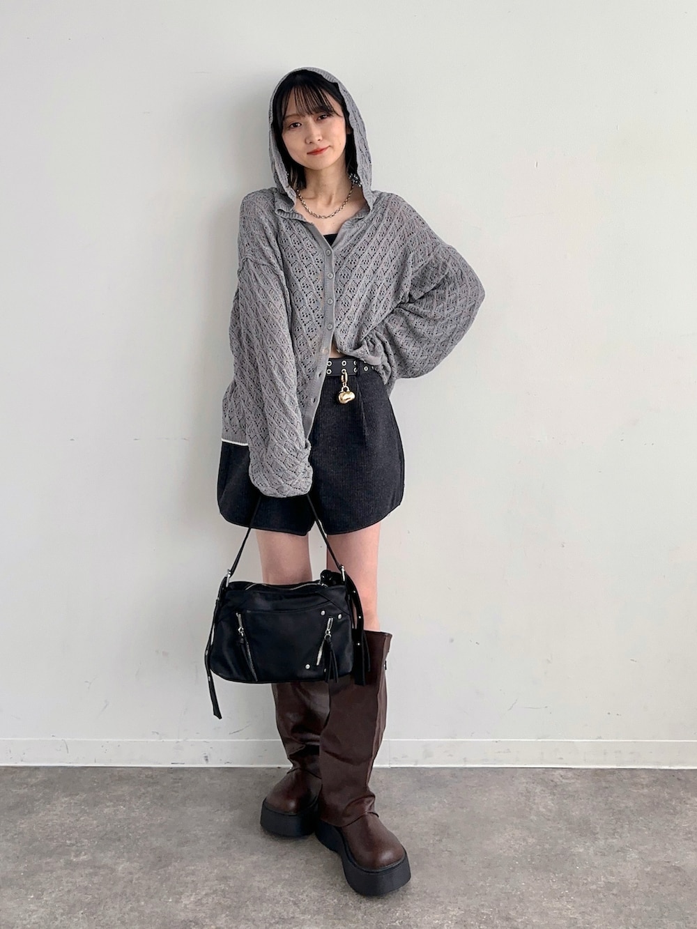グレー系のニット/セーター、グレー系のその他パンツ、ブラウン系のブーツを着用したレディースの春コーディネートの2枚目の写真