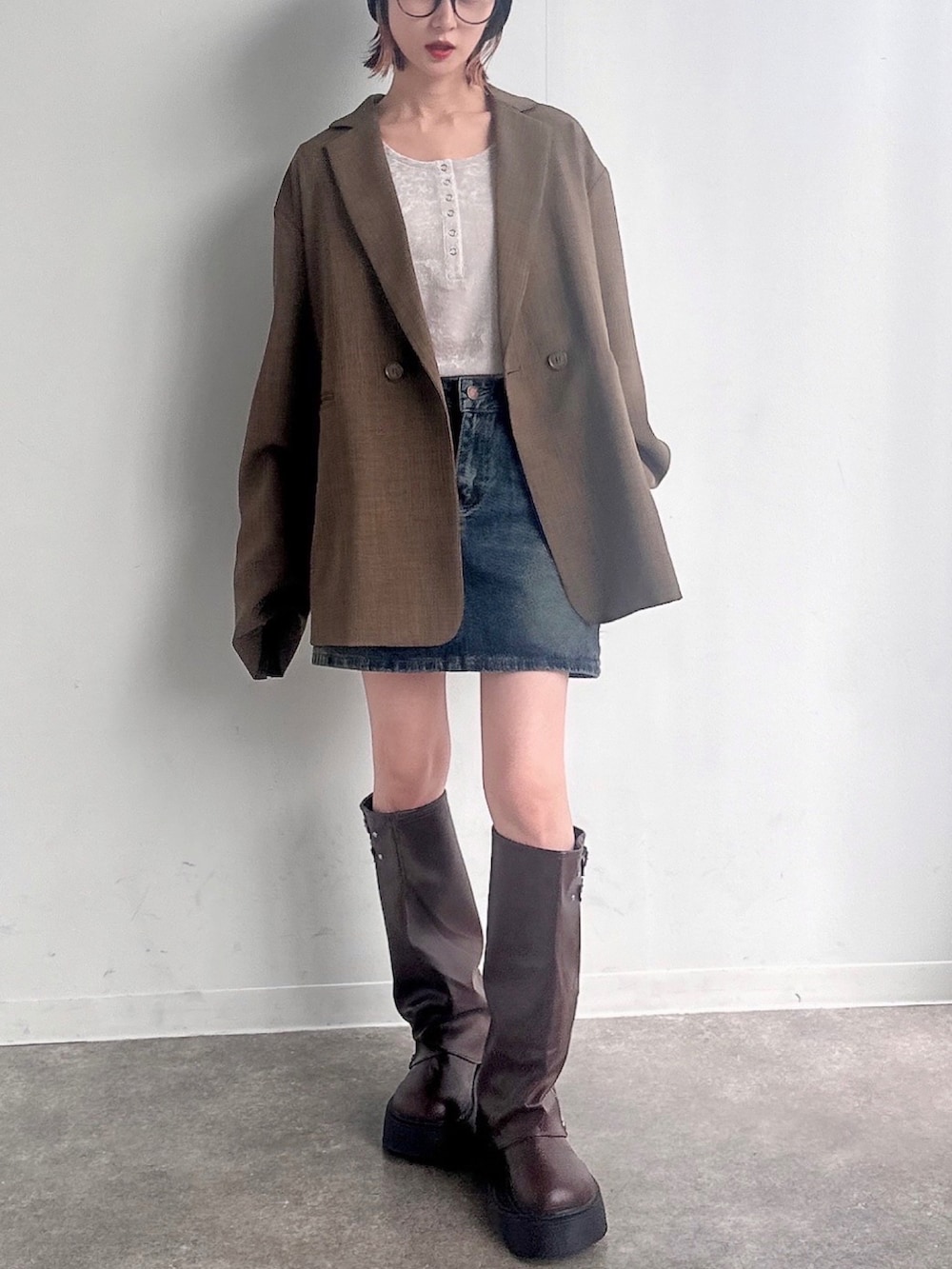 ブラウン系のテーラードジャケット、ホワイト系のTシャツ/カットソー、ブラウン系のブーツを着用したレディースの秋コーディネートの2枚目の写真