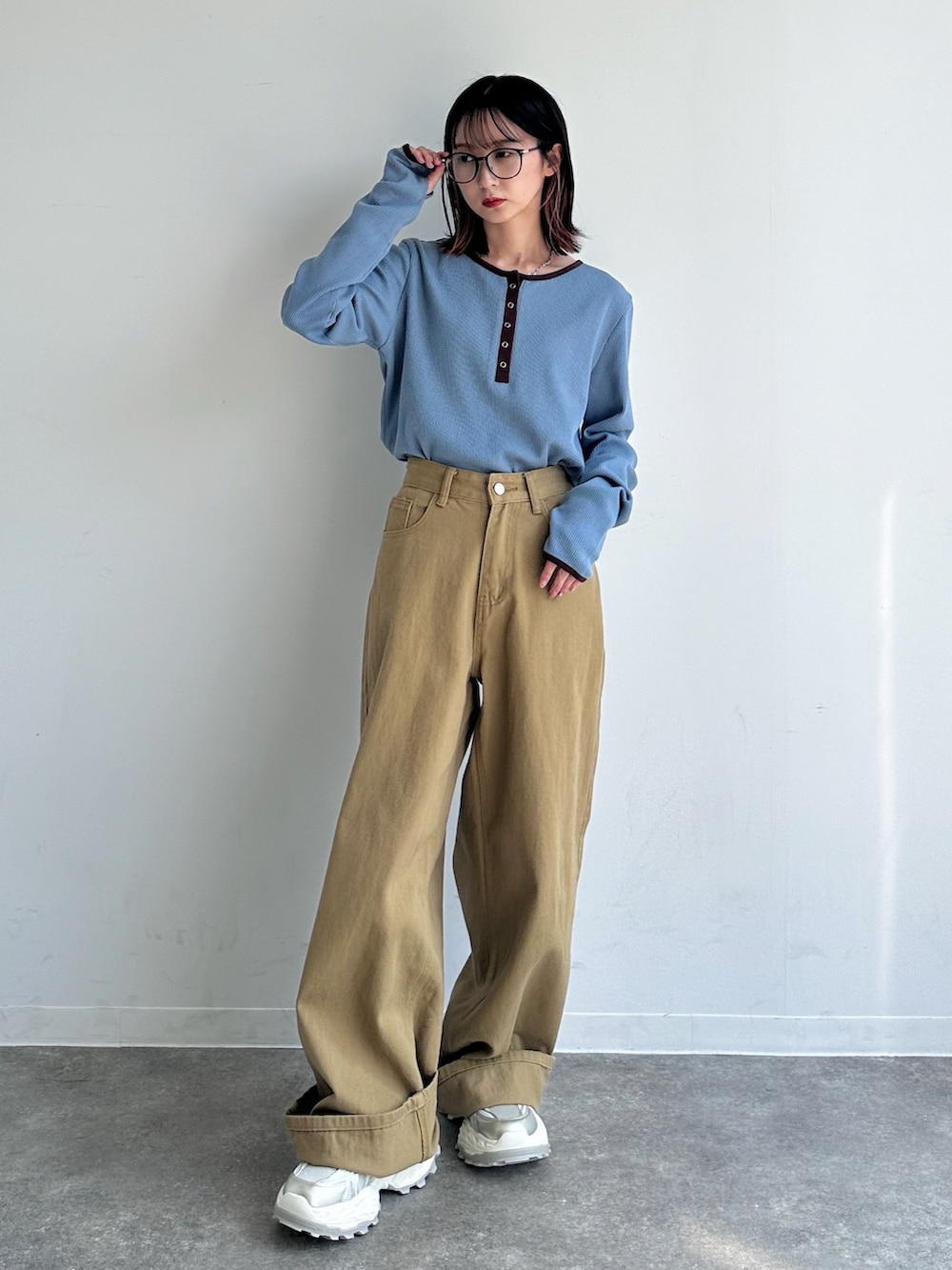 ブルー系のTシャツ/カットソー、ベージュ系のデニムパンツ、ホワイト系のスニーカーを着用したレディースの秋コーディネートの2枚目の写真