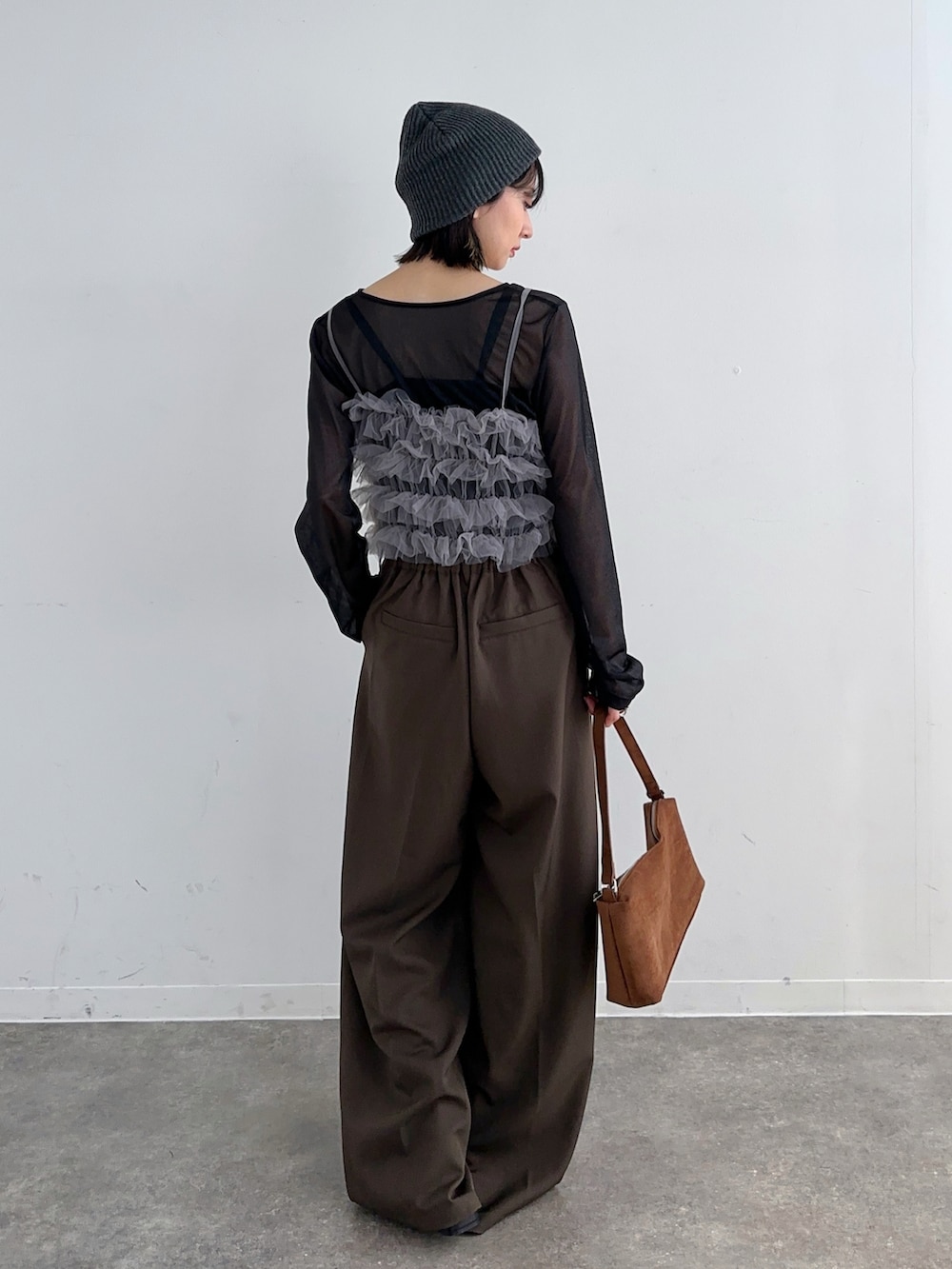 ブラック系のTシャツ/カットソー、グレー系のキャミソール、ブラウン系のスラックスを着用したレディースの春コーディネートの2枚目の写真