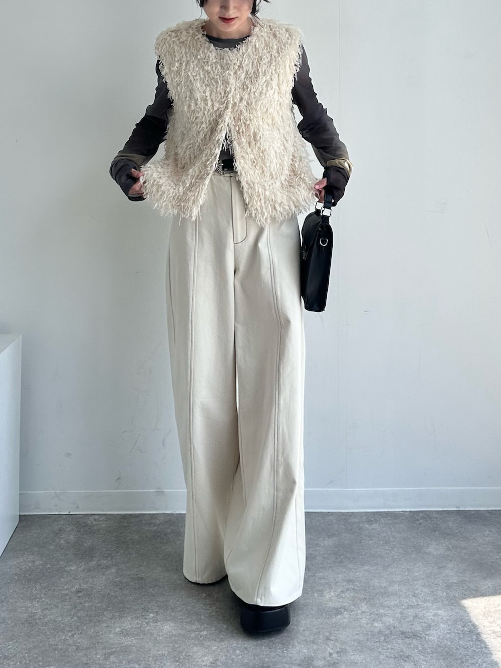 ホワイト系のベスト、ホワイト系のその他パンツ、ブラック系のTシャツ/カットソーを着用したレディースの春コーディネートの4枚目の写真