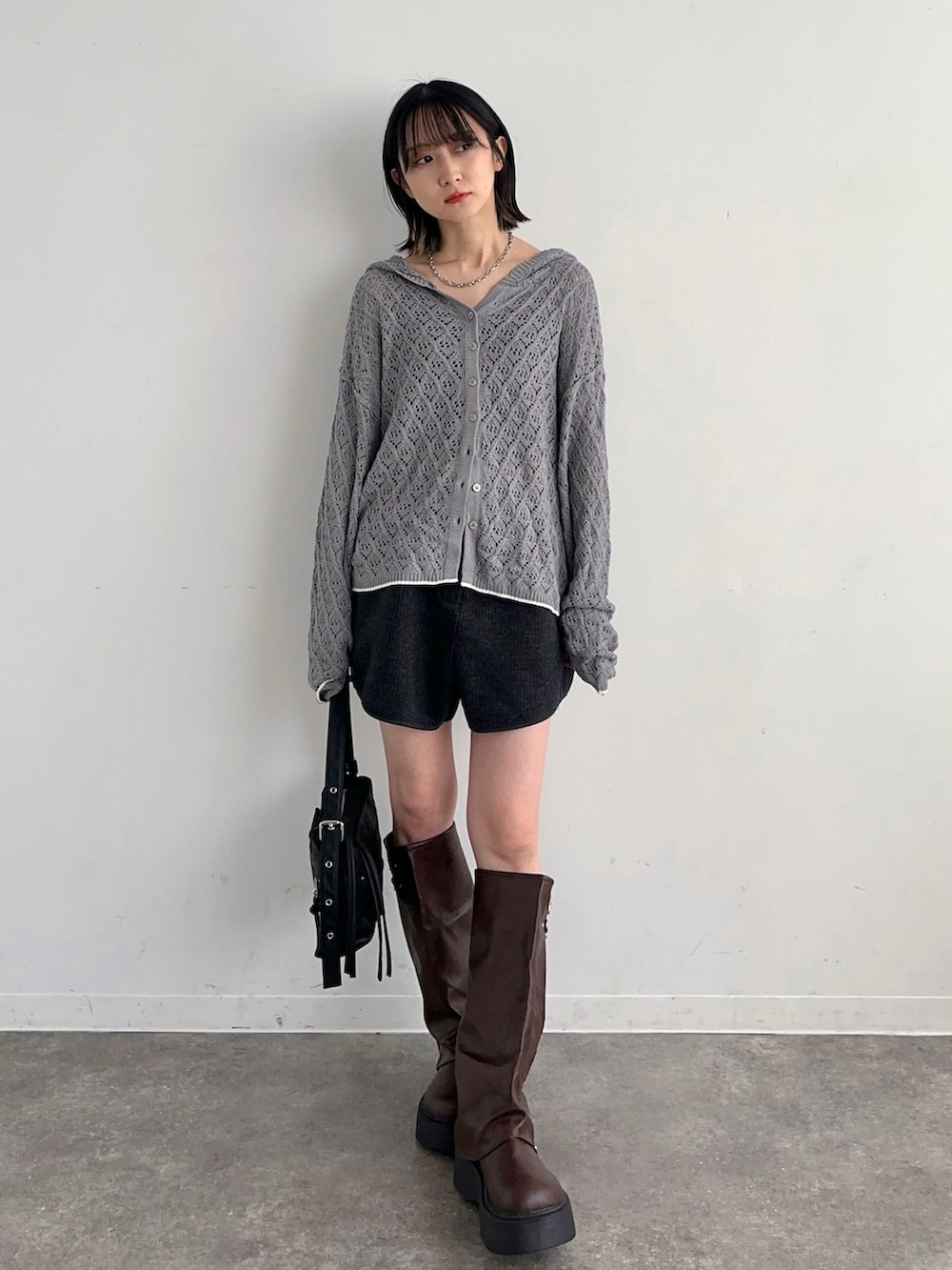 グレー系のニット/セーター、グレー系のその他パンツ、ブラウン系のブーツを着用したレディースの春コーディネートの3枚目の写真