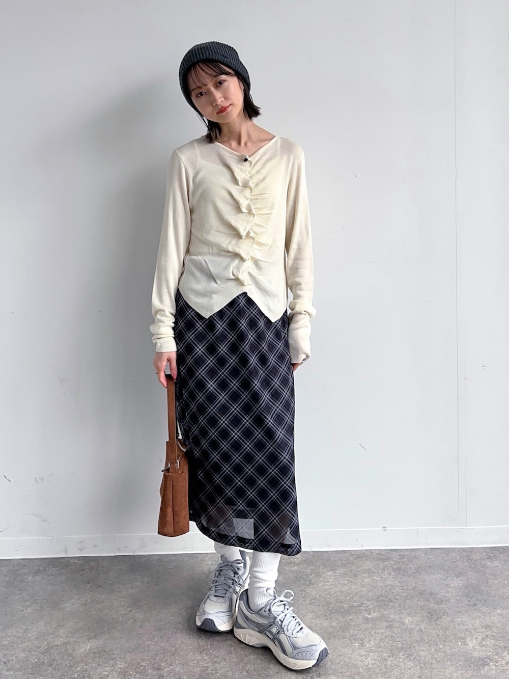 ホワイト系のカーディガン/ボレロ、ブラック系のスカート、グレー系のスニーカーを着用したレディースの春コーディネートの3枚目の写真