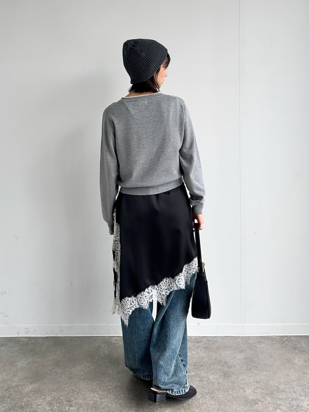 ブルー系のデニムパンツ、ブラック系のハンドバッグ、グレー系のカーディガン/ボレロを着用したレディースの春コーディネートの4枚目の写真