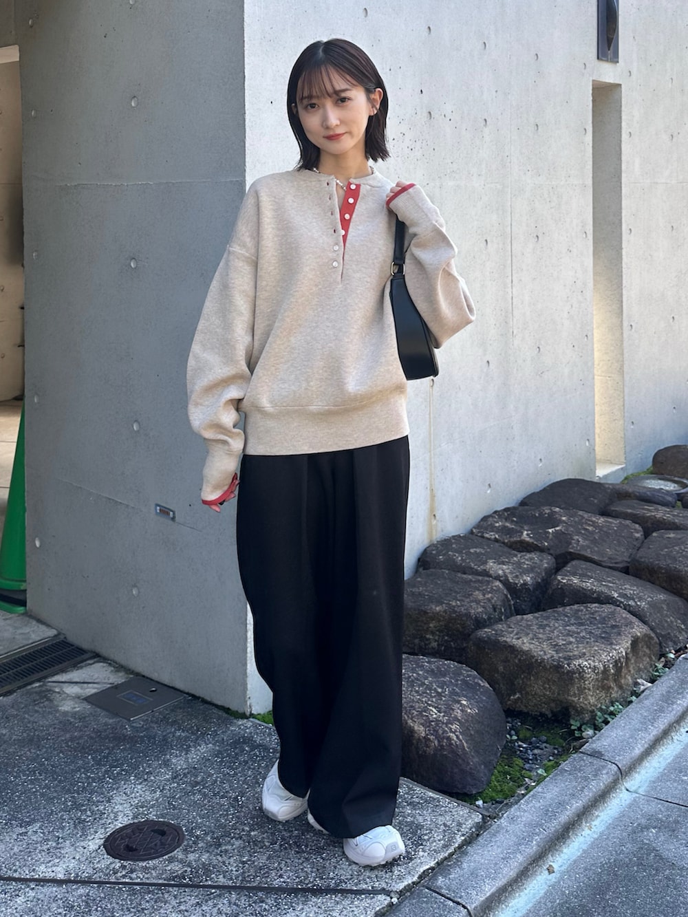 ベージュ系のニット/セーター、ブラック系のスラックス、ブラック系のハンドバッグを着用したレディースの秋コーディネートの5枚目の写真