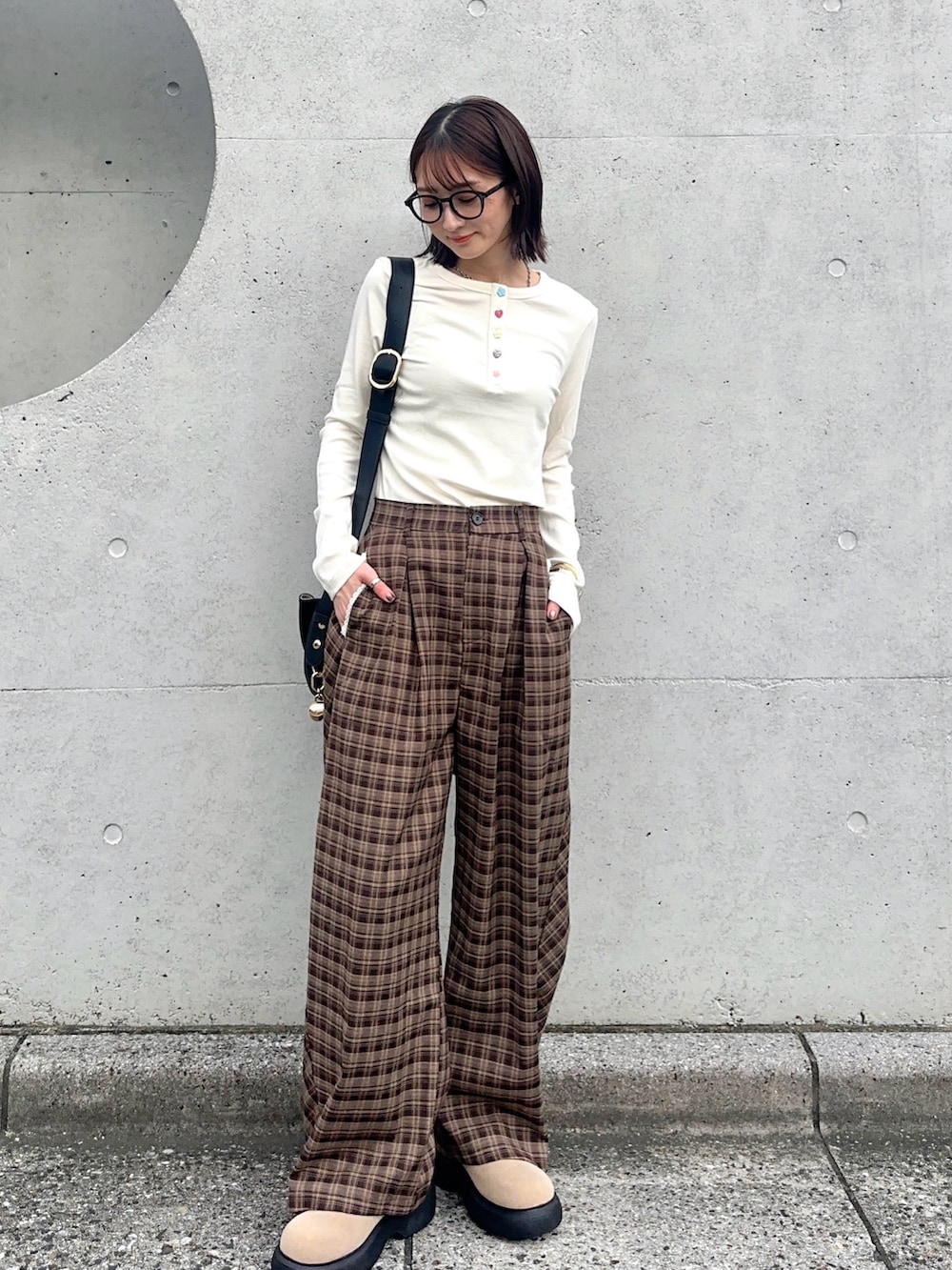 ホワイト系のTシャツ/カットソー、ブラウン系のその他パンツ、ブラック系のハンドバッグを着用したレディースの秋コーディネートの3枚目の写真