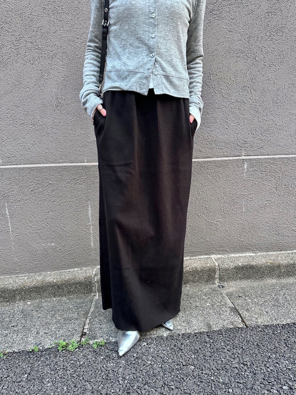 グレー系のカーディガン/ボレロ、ホワイト系のカーディガン/ボレロ、ブラック系のスカートを着用したレディースの春コーディネートの3枚目の写真