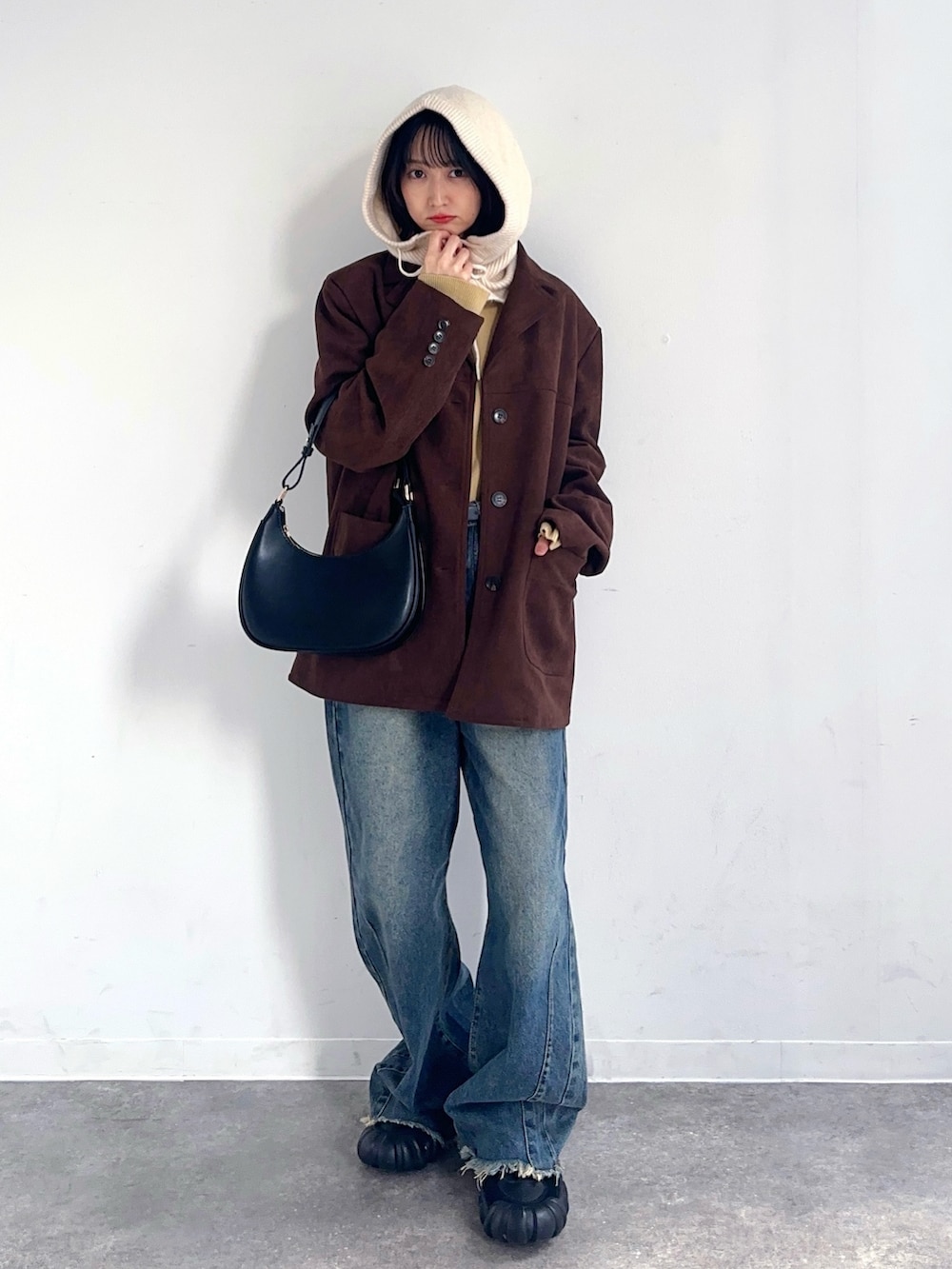 ブラウン系のテーラードジャケット、グリーン系のデニムパンツ、ブラック系のスニーカーを着用したレディースの秋コーディネートの2枚目の写真