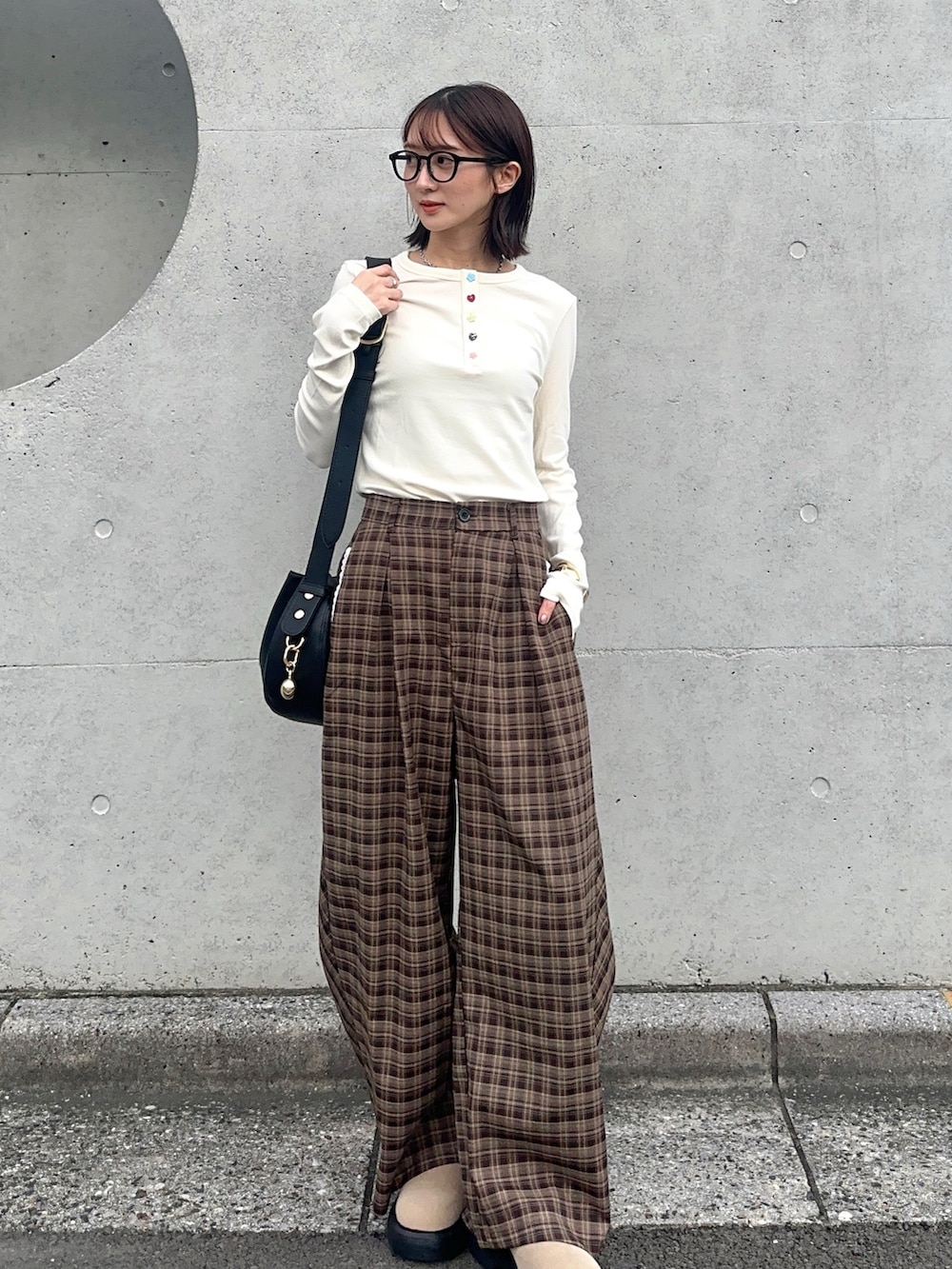 ホワイト系のTシャツ/カットソー、ブラウン系のその他パンツ、ブラック系のハンドバッグを着用したレディースの秋コーディネートの2枚目の写真