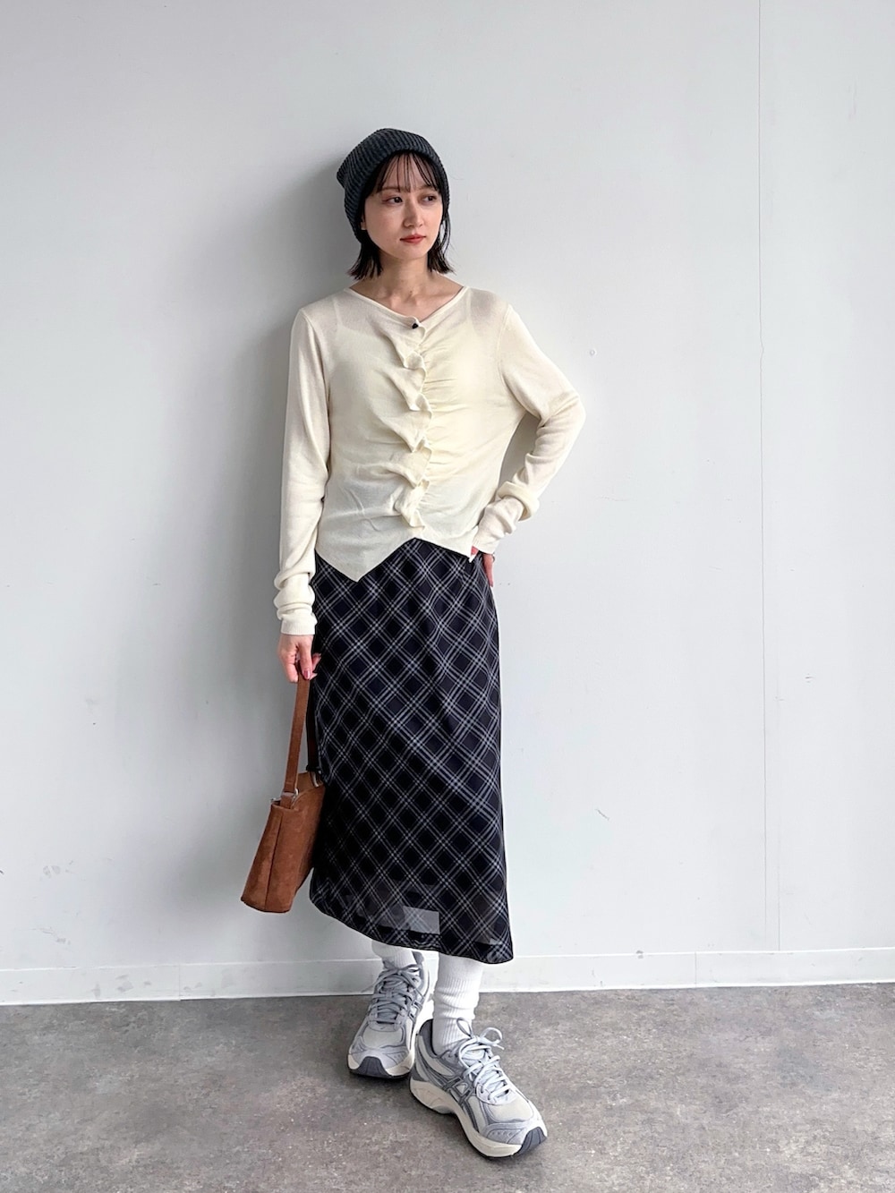 ホワイト系のカーディガン/ボレロ、ブラック系のスカート、グレー系のスニーカーを着用したレディースの春コーディネートの2枚目の写真
