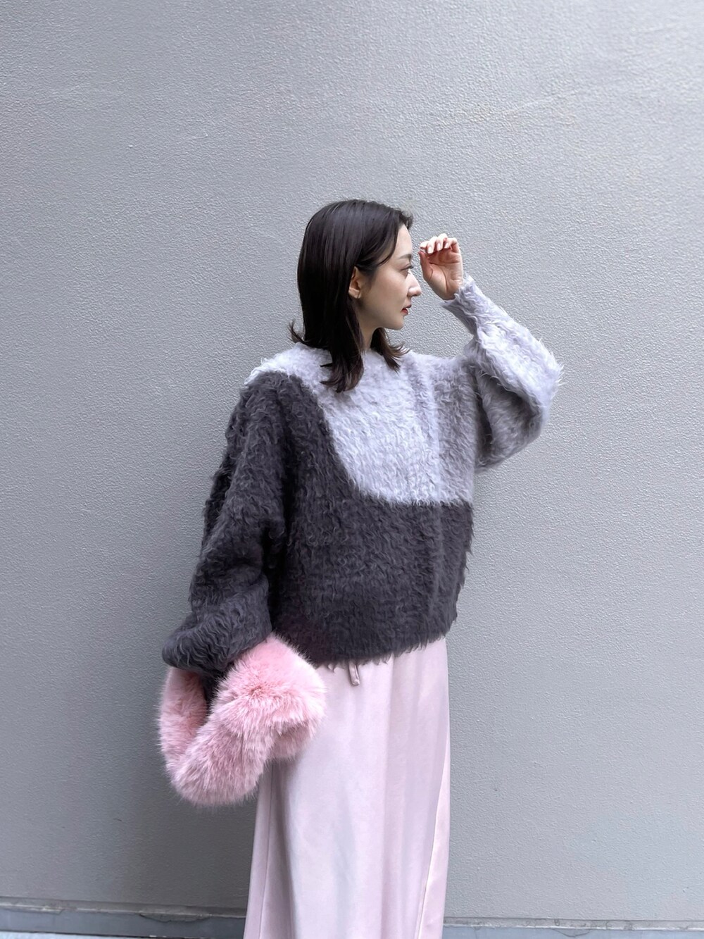 ブラック系のニット/セーター、ピンク系のスカートを着用したレディースの冬コーディネートの2枚目の写真