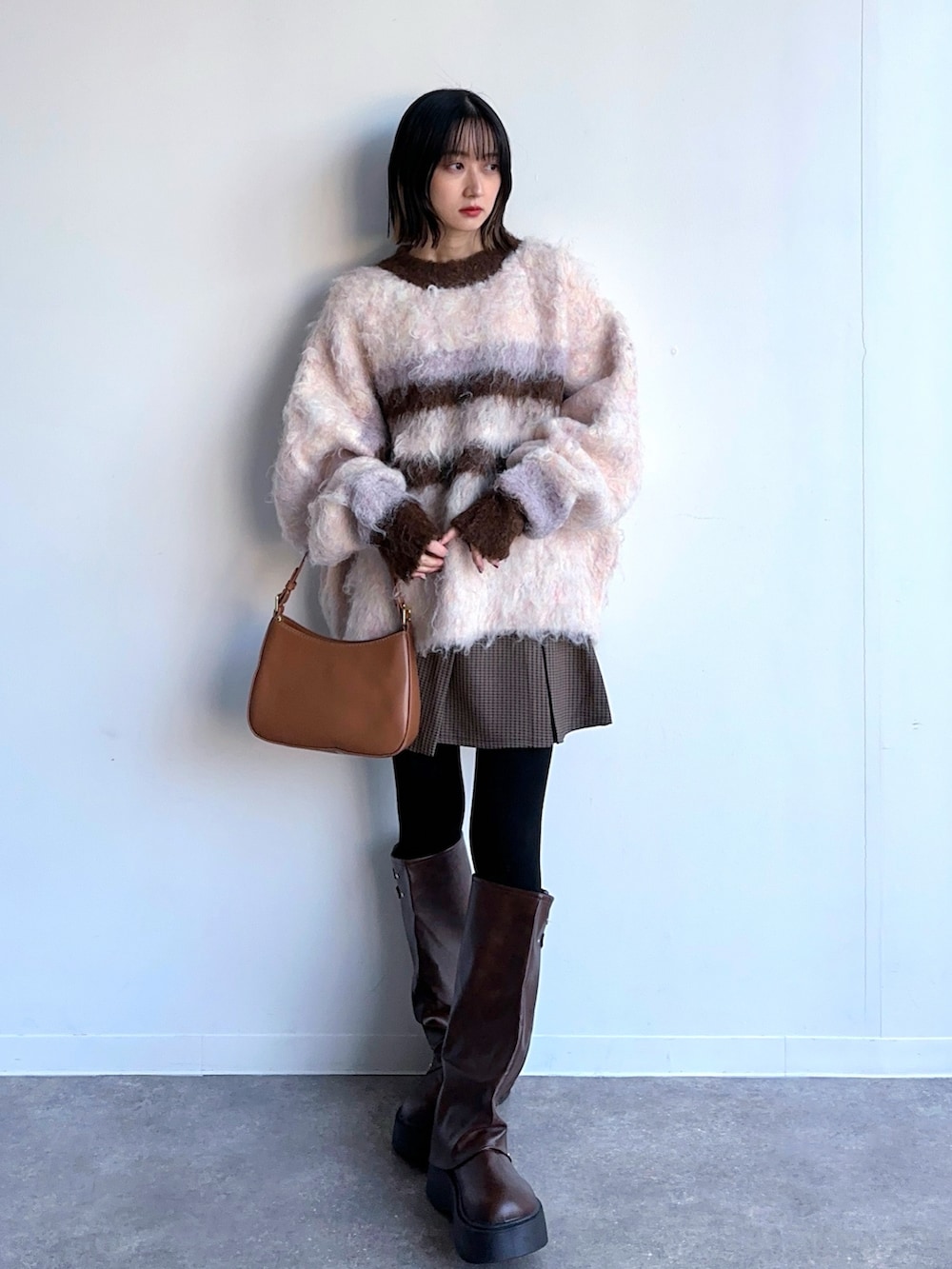 ピンク系のニット/セーター、その他のスカート、ブラウン系のブーツを着用したレディースの冬コーディネートの2枚目の写真
