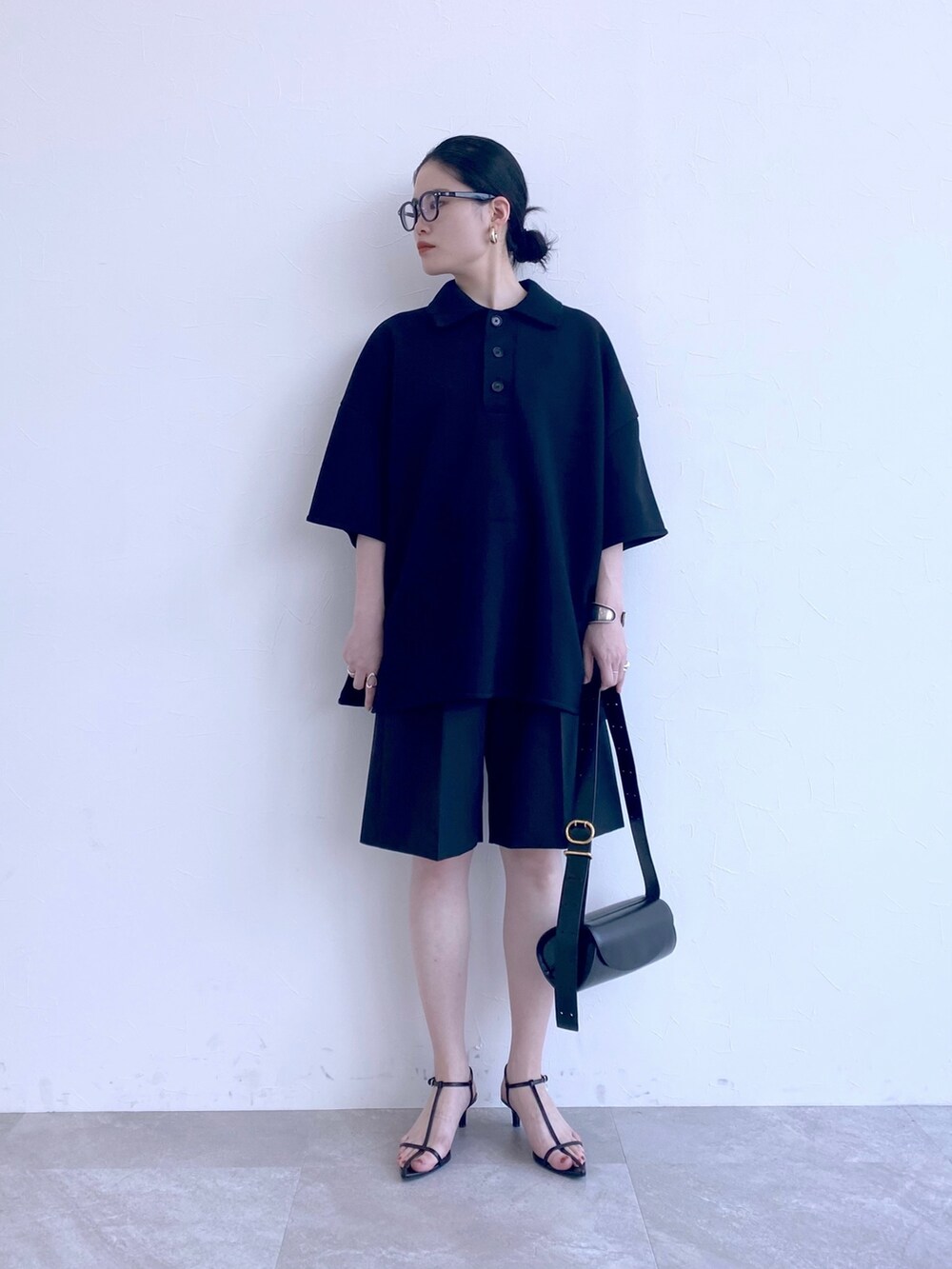 ブラック系のその他パンツ、ブラック系のポロシャツを着用したレディースの春コーディネートの2枚目の写真