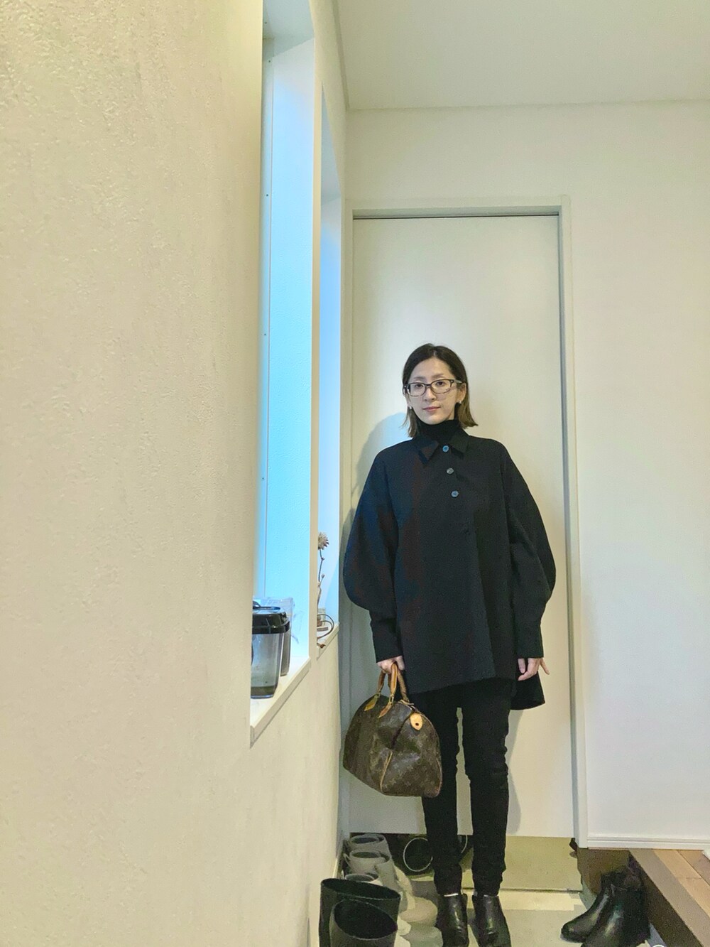 その他のバッグ、ブラック系のトップス、ブラック系のデニムパンツを着用したレディースの冬コーディネートの2枚目の写真