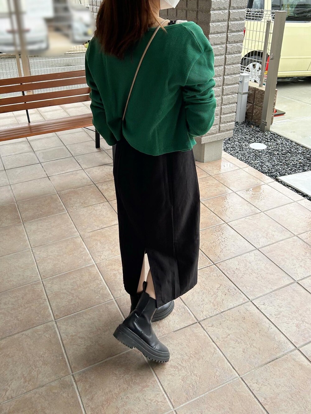 ブラック系のブーツ、ブラック系のワンピース、グリーン系のカーディガン/ボレロを着用したレディースの秋コーディネートの2枚目の写真