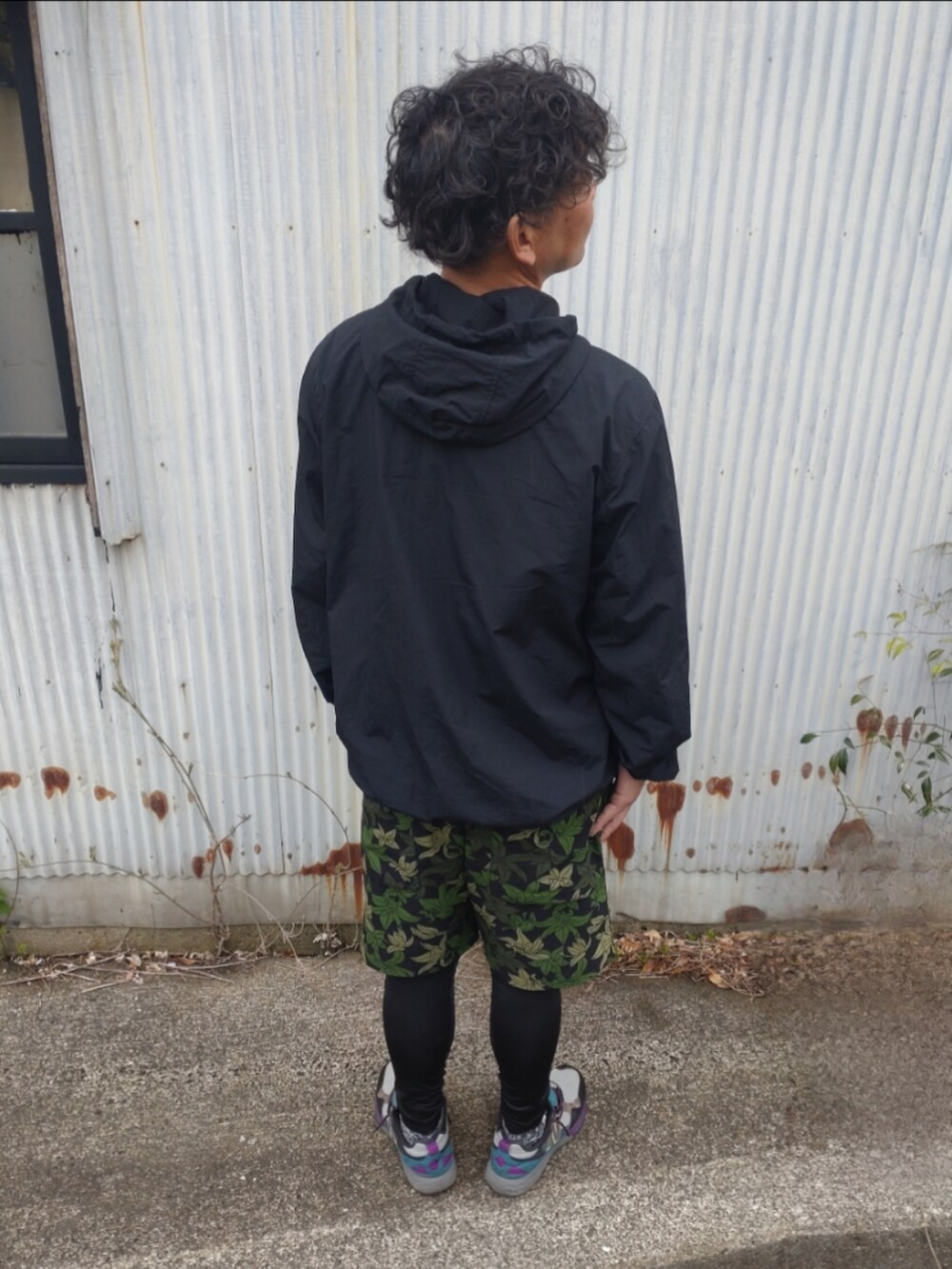 ブラック系のナイロンジャケット、グリーン系のその他パンツ、その他のスニーカーを着用したメンズの春コーディネートの2枚目の写真