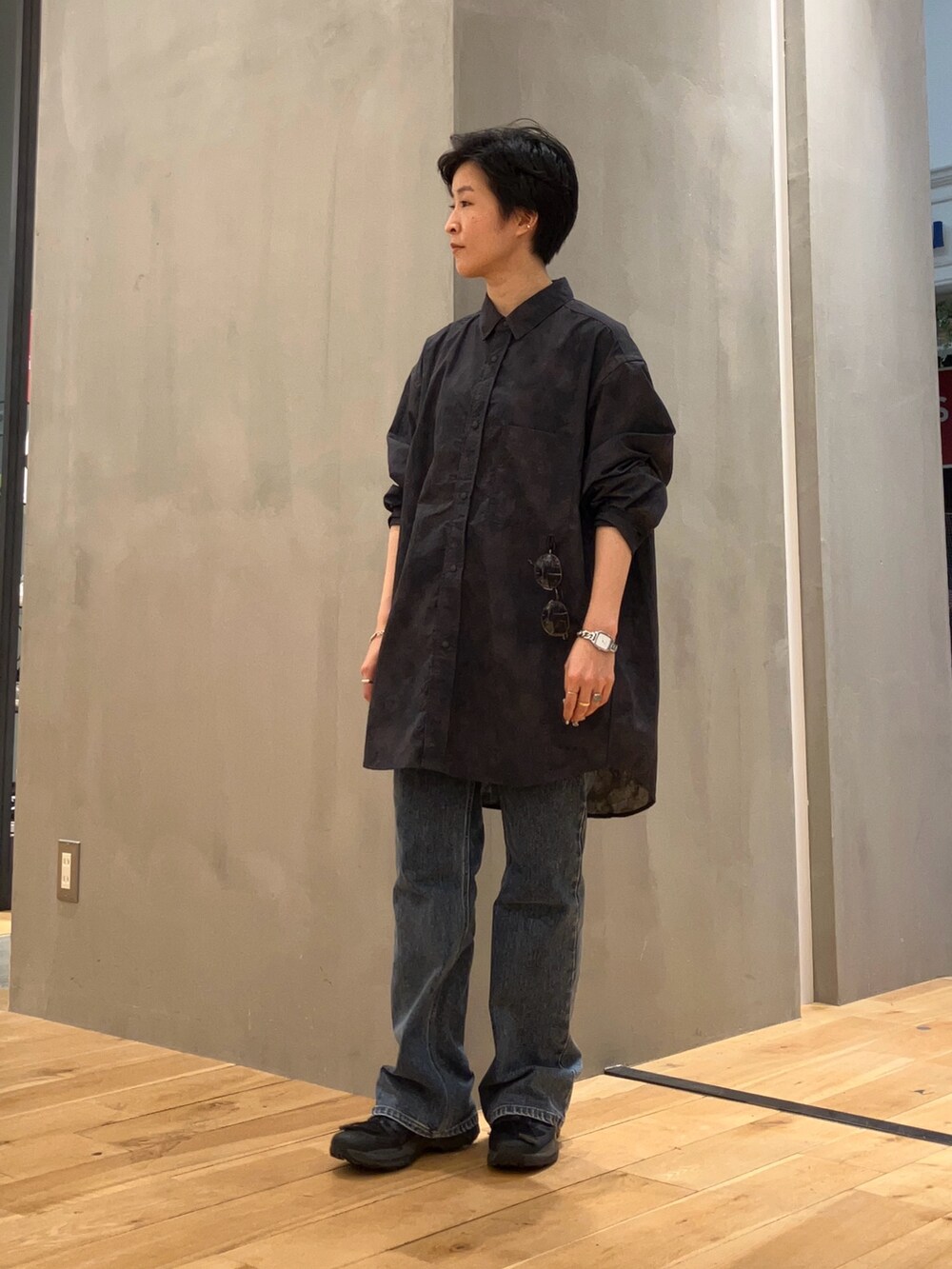 ブルー系のデニムパンツ、グレー系のショルダーバッグ、ブラック系のスニーカーを着用したレディースの夏コーディネートの4枚目の写真