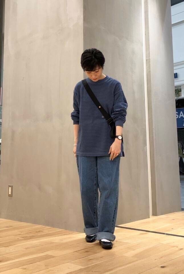 ブラック系のバレエシューズ、ブルー系のデニムパンツ、ブラック系のショルダーバッグを着用したレディースの夏コーディネートの2枚目の写真