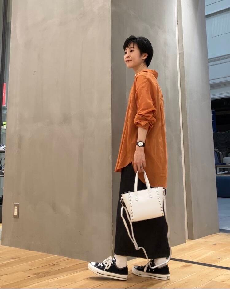 ブラック系のワンピース、ブラック系のスニーカー、ホワイト系のショルダーバッグを着用したレディースの夏コーディネートの2枚目の写真