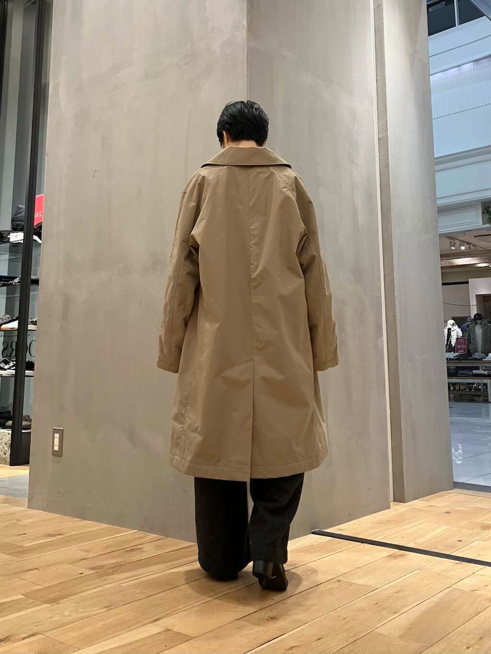 ブラウン系のニット/セーター、ブラウン系のステンカラーコート、グレー系のサロペット/オーバーオールを着用したレディースの冬コーディネートの4枚目の写真