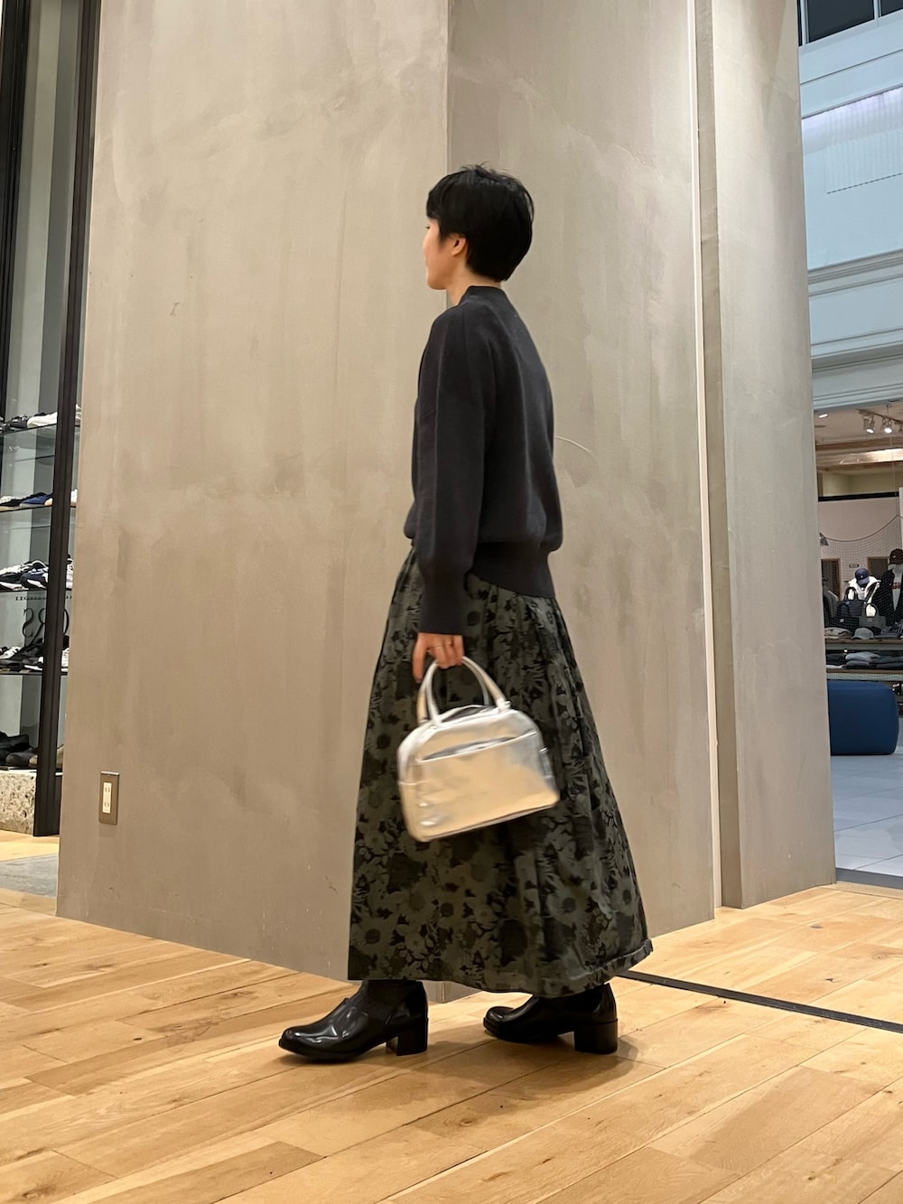 グレー系のニット/セーター、ベージュ系のその他アウター、シルバー系のショルダーバッグを着用したレディースの冬コーディネートの3枚目の写真