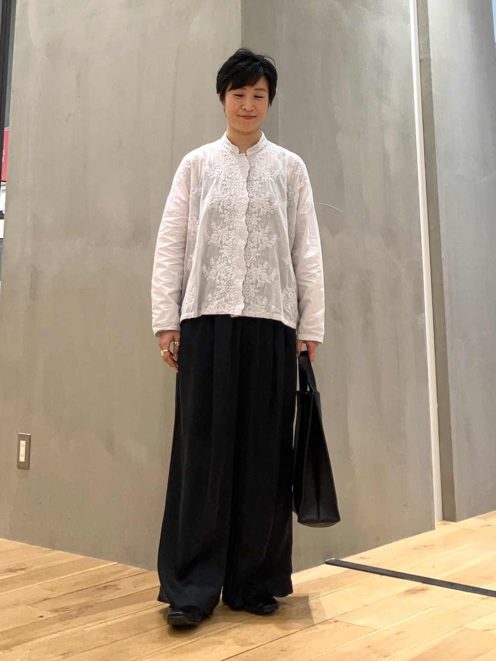 グレー系のシャツ/ブラウス、ブルー系のその他パンツ、ブラック系のハンドバッグを着用したレディースの夏コーディネートの2枚目の写真