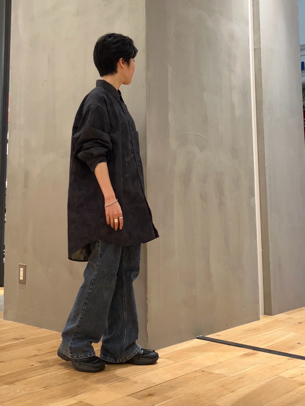 ブルー系のデニムパンツ、グレー系のショルダーバッグ、ブラック系のスニーカーを着用したレディースの夏コーディネートの2枚目の写真