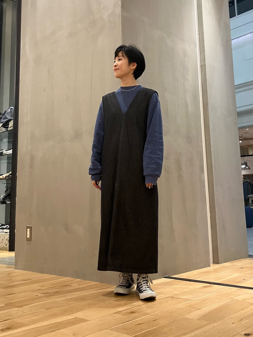 ブラック系のワンピース、ブラック系のボストンバッグ、ブラック系のスニーカーを着用したレディースの秋コーディネートの4枚目の写真