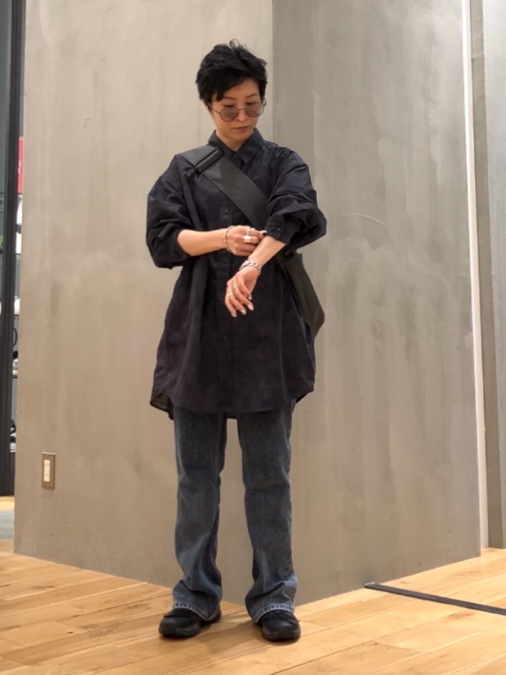 ブルー系のデニムパンツ、グレー系のショルダーバッグ、ブラック系のスニーカーを着用したレディースの夏コーディネートの5枚目の写真