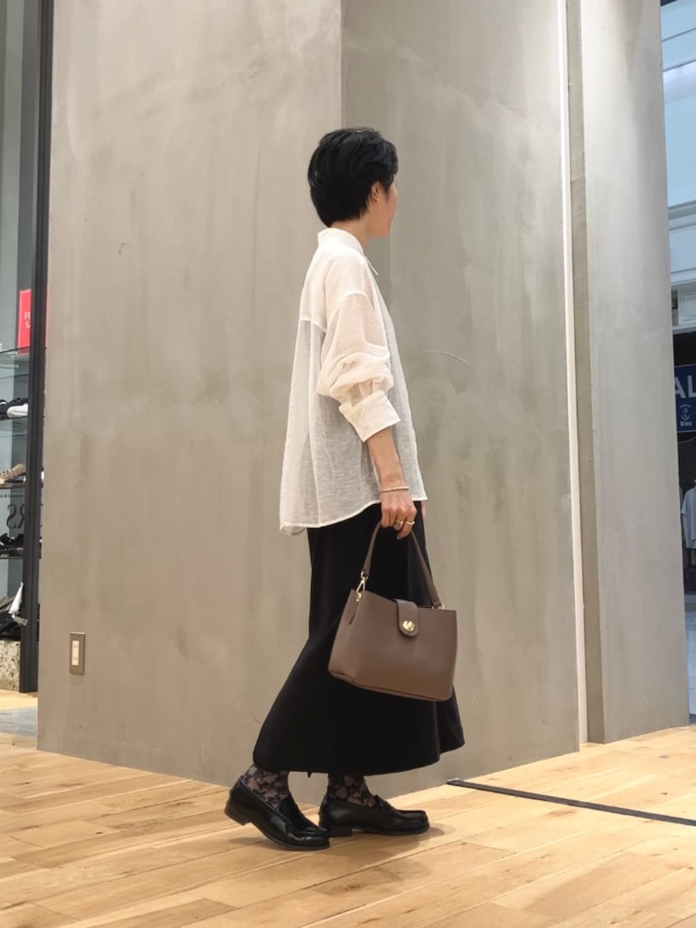 ホワイト系のシャツ/ブラウス、ブラック系のスカート、ブラウン系のショルダーバッグを着用したレディースの夏コーディネートの3枚目の写真