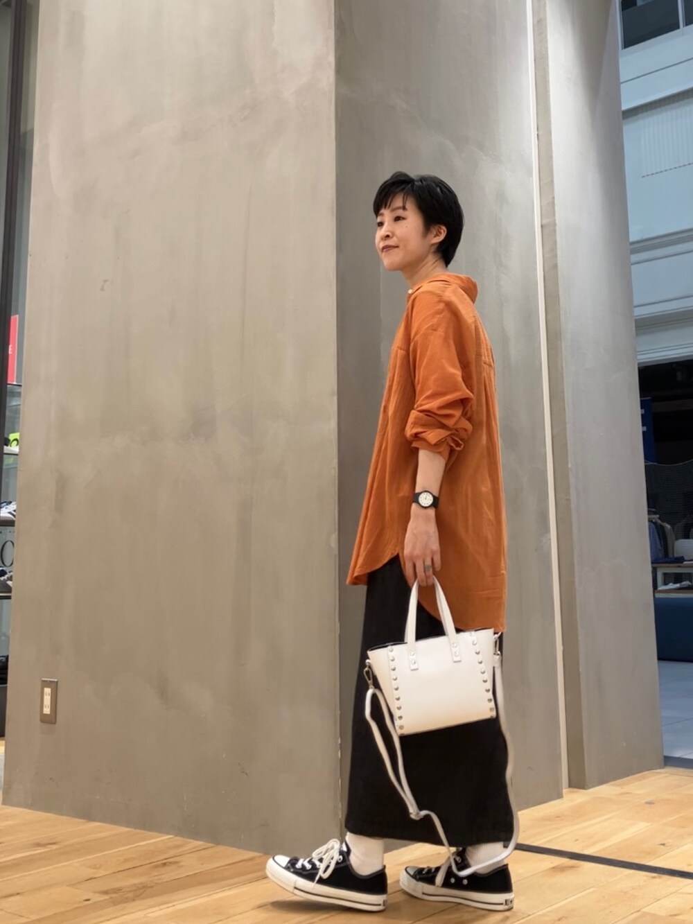 ブラック系のワンピース、オレンジ系のシャツ/ブラウス、ホワイト系のTシャツ/カットソーを着用したレディースの夏コーディネートの2枚目の写真