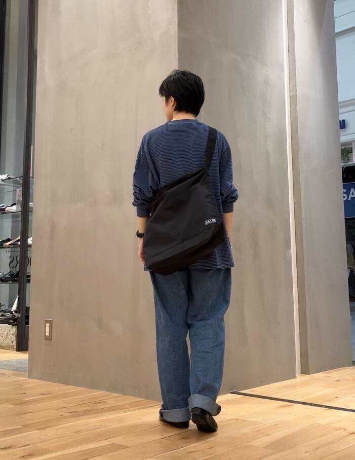 ブラック系のバレエシューズ、ブルー系のデニムパンツ、ブラック系のショルダーバッグを着用したレディースの夏コーディネートの4枚目の写真