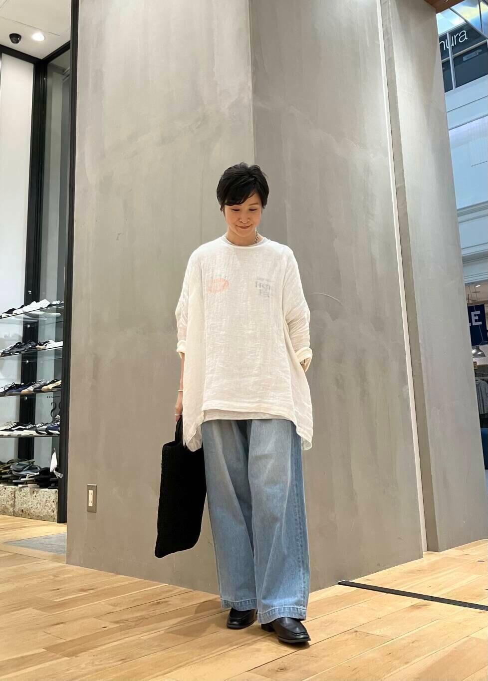 グレー系のTシャツ/カットソー、ブラック系のサンダル、ブルー系のデニムパンツを着用したレディースの夏コーディネートの2枚目の写真