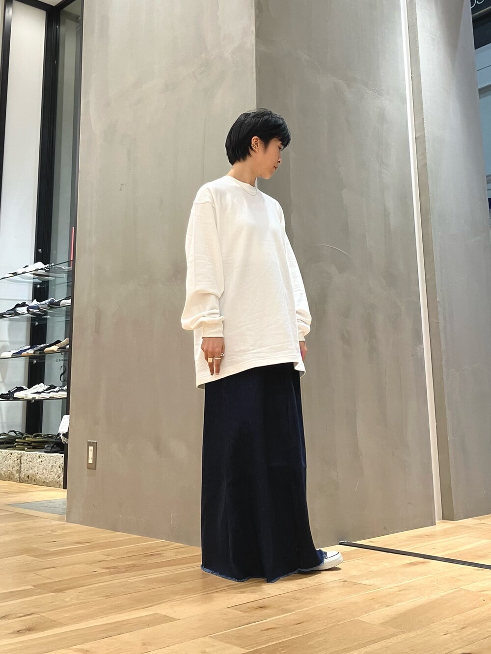 ブルー系のスカート、ブルー系のトートバッグ、ブラック系のスニーカーを着用したレディースの夏コーディネートの6枚目の写真