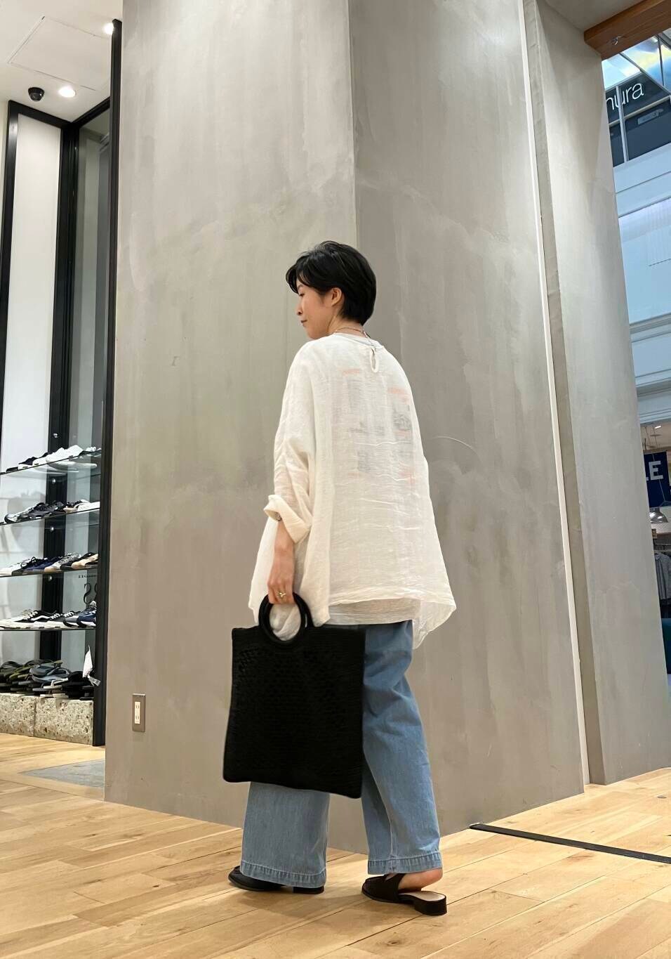 グレー系のTシャツ/カットソー、ブラック系のサンダル、ブルー系のデニムパンツを着用したレディースの夏コーディネートの3枚目の写真