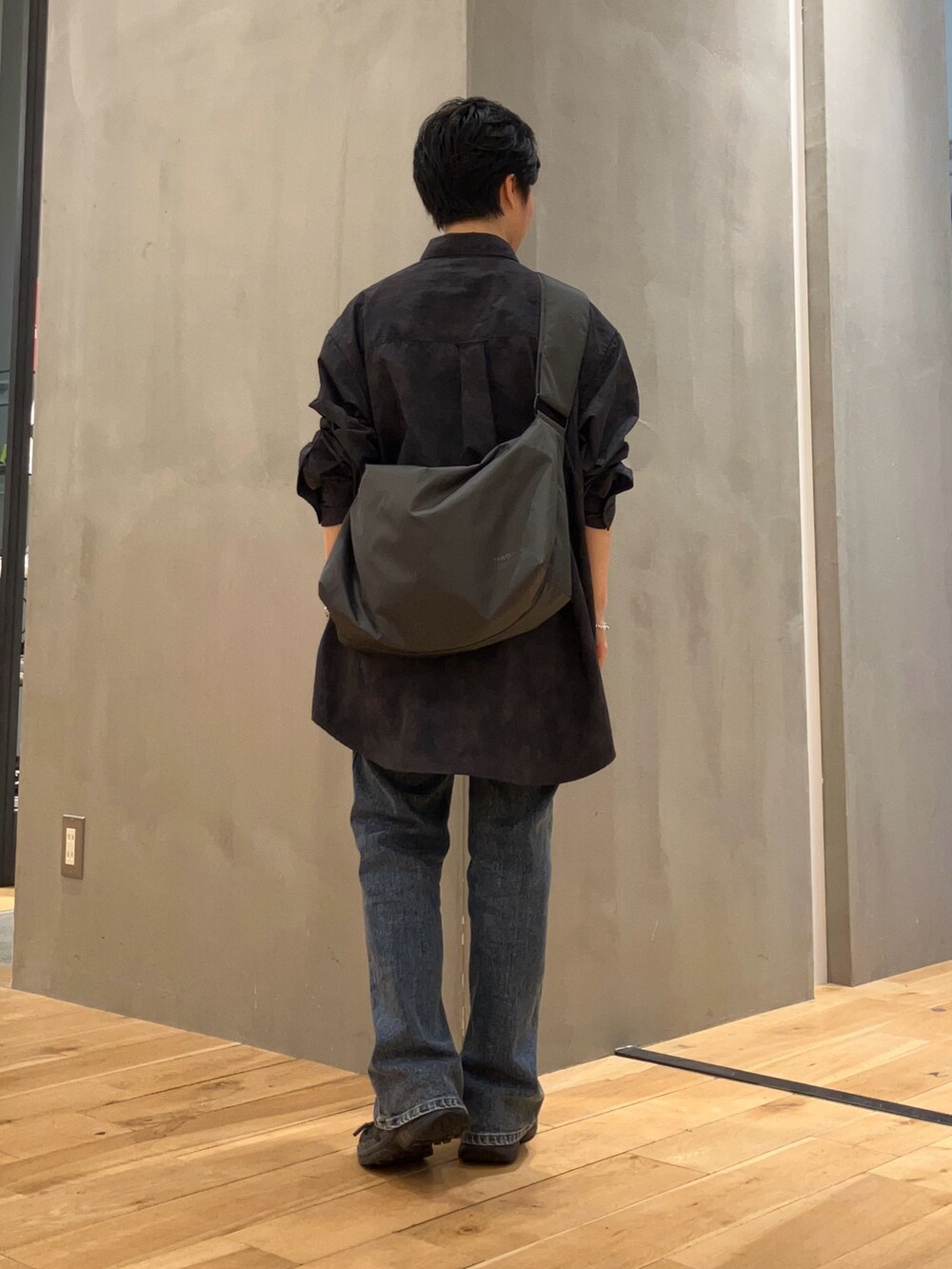 ブルー系のデニムパンツ、グレー系のショルダーバッグ、ブラック系のスニーカーを着用したレディースの夏コーディネートの3枚目の写真