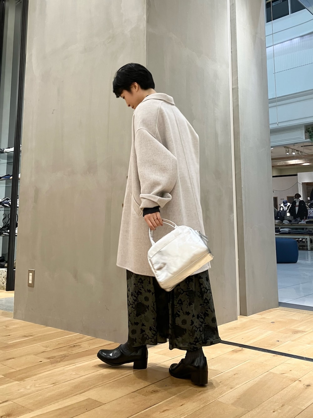 グレー系のニット/セーター、ベージュ系のその他アウター、シルバー系のショルダーバッグを着用したレディースの冬コーディネートの7枚目の写真