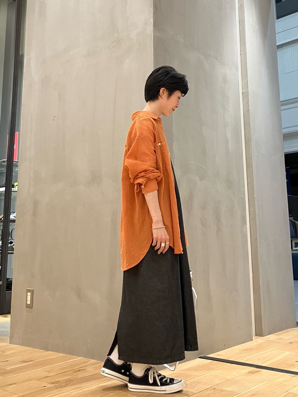 ブラック系のワンピース、オレンジ系のシャツ/ブラウス、ホワイト系のTシャツ/カットソーを着用したレディースの夏コーディネートの3枚目の写真