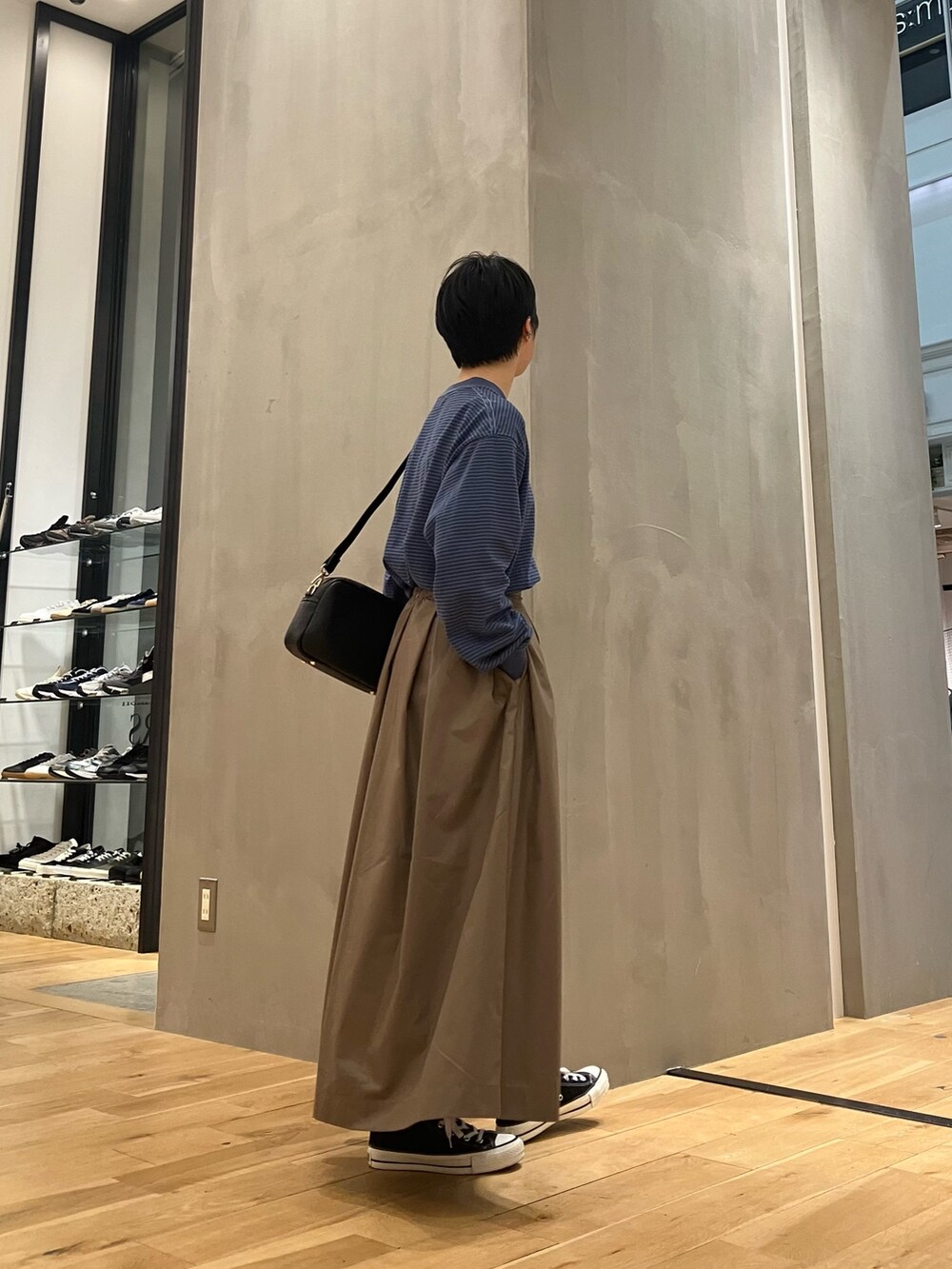 ブルー系のTシャツ/カットソー、ブラウン系のブルゾン、ブラウン系のスカートを着用したレディースの秋コーディネートの5枚目の写真