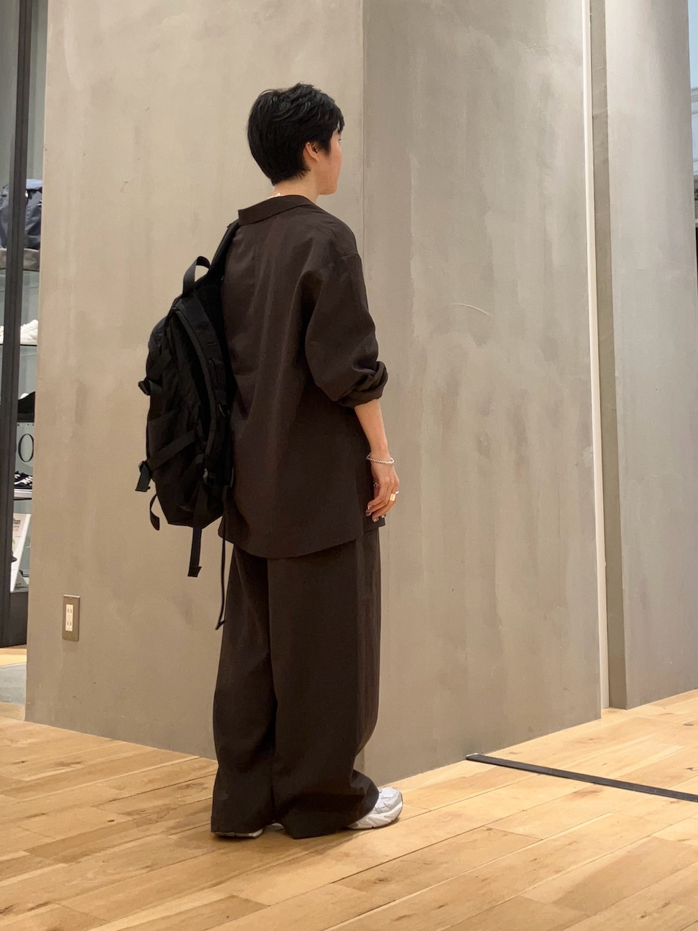 ブラック系のバックパック/リュック、シルバー系のスニーカー、ホワイト系のTシャツ/カットソーを着用したレディースの秋コーディネートの3枚目の写真