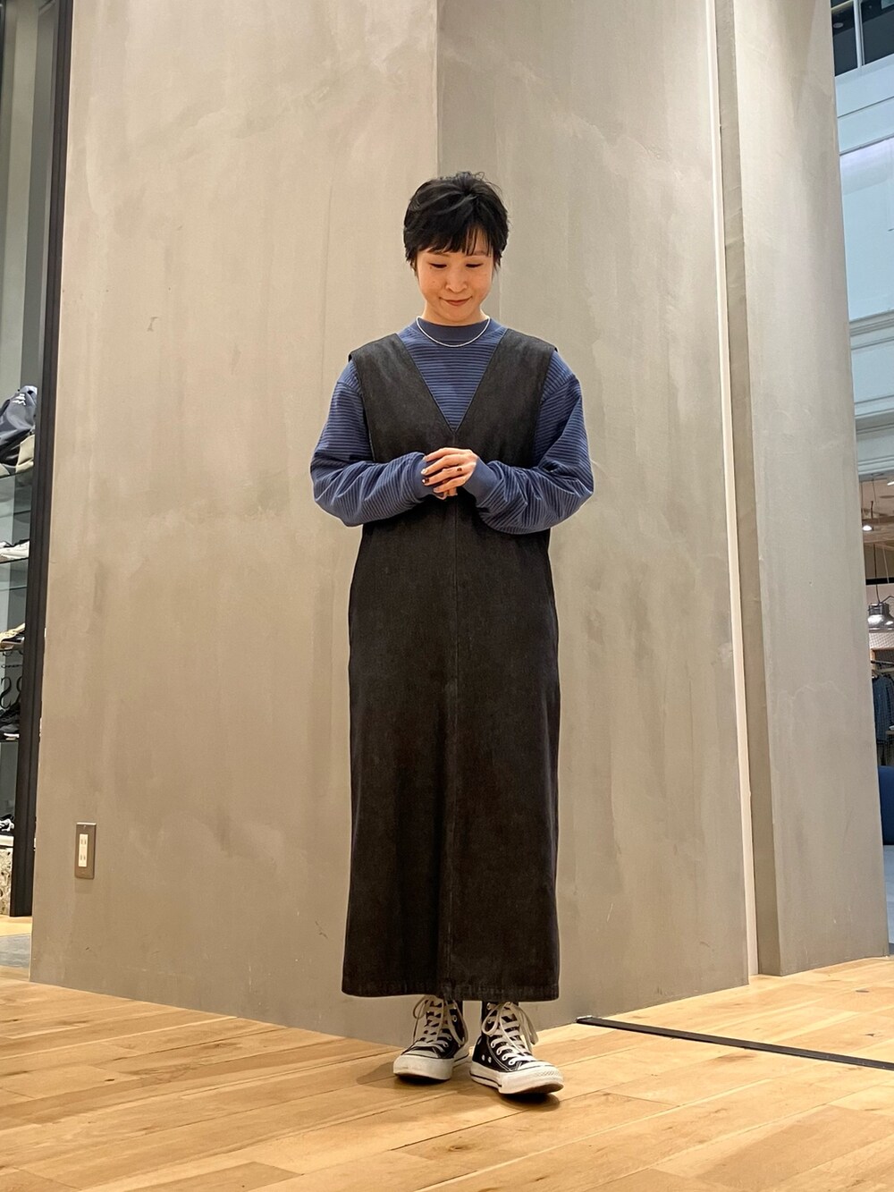 ブラック系のワンピース、ブラック系のボストンバッグ、ブラック系のスニーカーを着用したレディースの秋コーディネートの2枚目の写真