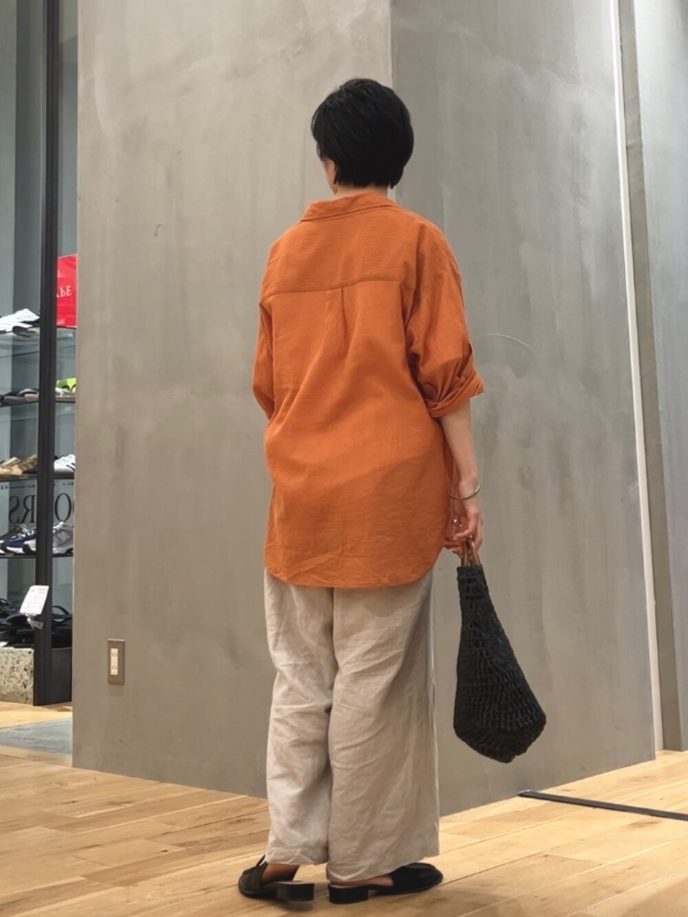 ベージュ系のその他パンツ、オレンジ系のシャツ/ブラウス、ブラック系のローファーを着用したレディースの夏コーディネートの4枚目の写真